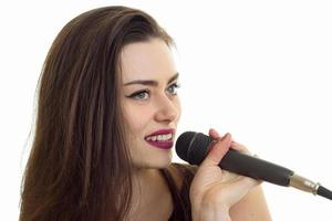 retrato de primer plano de una joven cantante elegante con un micrófono foto