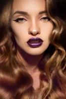 Close up portrait of beautiful girl with perfect curly hairstyle and makeup with magenta gloss lips looking at the camera photo