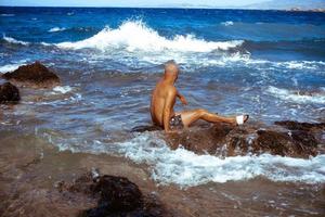 hombre guapo en la costa rocosa marina foto