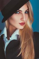 Charming blonde woman in black hat looking at camera photo