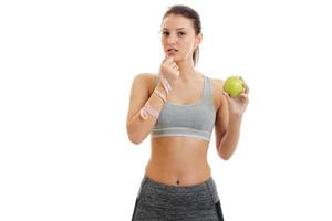 beautiful fitness girl looks ahead and holds in his hand a Apple photo