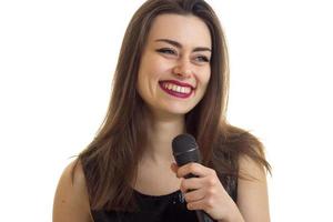 mujer alegre con hermoso maquillaje sonriendo con micrófono en las manos