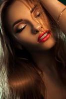 close up portrait of beautiful woman with red lips and closed eyes photo