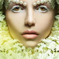 square portrait of lovely young woman with tender makeup and flowers photo