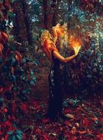 awesome young witch conjures in the forest photo