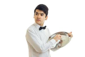 beautiful strong young waiter looks away and rub hand food tray photo