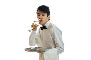 hermoso camarero carismático bebiendo champán de una copa foto