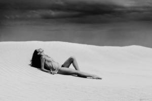 Sexy woman lying in desert photo