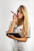 Nurse thinking and take pen in mouth photo