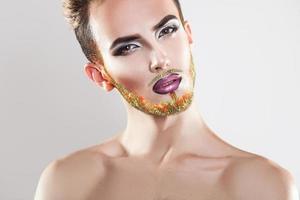 Portrait of nice male model with makeup and multicolor beard photo