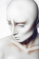 Hairless pretty woman with white paint on body and face photo