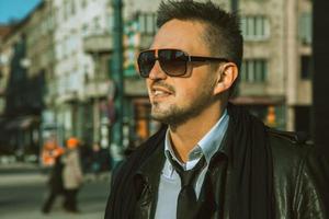 Portrait of beautiful adult male in sunglasses and tie looking away photo