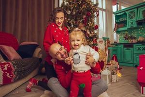 Cheerful family with daughter celebrate Christmas and New year together photo