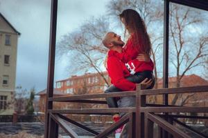 hermosa pareja se abraza en un balcón en invierno. humor navideño foto