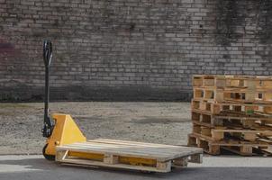 carro hidráulico con palet de madera para carga. transpaleta foto