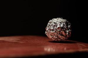 round ball of metal foil on the table. photo