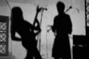 en la pared la sombra de un músico guitarrista durante un concierto. foto