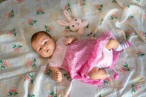 Adorable newborn girl in pink dress photo