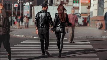 beautiful couple walks across the road photo