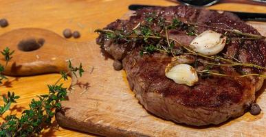 tasty ribeye steak with thyme and garlic photo