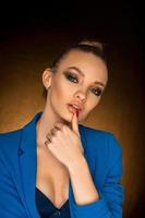 Beautiful young girl in blue jacket with beauty makeup in studio photo