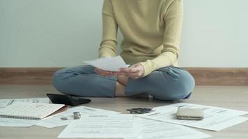 las mujeres tienen estrés severo debido a la deuda. la mujer está sentada en la prensa de varias calculadoras de gastos en facturas y deudas de tarjetas de crédito. mujer no hay dinero con la deuda a pagar mensualmente. concepto de deuda. video