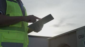 les ingénieurs des services publics revérifient l'état de l'air sur le toit-terrasse de l'usine. le concepteur du système de climatisation de l'usine a marché pour vérifier le fonctionnement du système. ingénieur de support. video