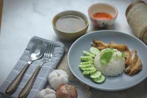 Hainanese chicken rice with fried chicken, fried chicken served with sweet dipping sauce and chicken broth, Asian style, street food commonly sold in Asia. photo