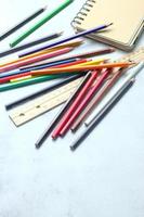 crayones de madera esparcidos sobre la mesa, reglas de madera y cuadernos con el festival de regreso al semestre, los estudiantes van a la escuela, clases de arte. foto