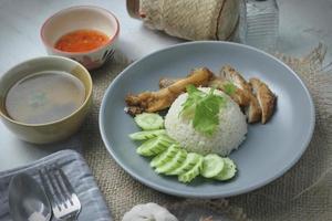 Hainanese chicken rice with fried chicken, fried chicken served with sweet dipping sauce and chicken broth, Asian style, street food commonly sold in Asia. photo