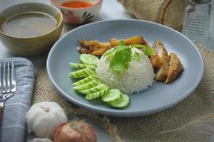 Hainanese chicken rice with fried chicken, fried chicken served with sweet dipping sauce and chicken broth, Asian style, street food commonly sold in Asia. photo