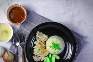 Hainanese chicken rice with soup or steamed chicken and sauces. photo