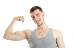 horizontal portrait of beautiful sports guy who smiles and shows his muscle on hand photo