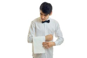 a young waiter's shirt carefully hangs towel on hand photo