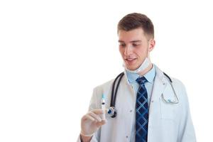 médico joven en uniforme con una jeringa en las manos foto