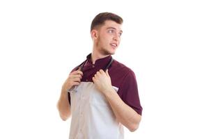 young smiling doctor holding stethoscope around his neck is isolated on a white background photo