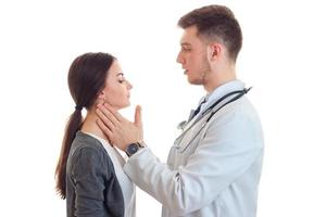 the doctor looks at the girl's throat and checks his hands photo