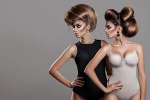 Horizontal portrait of two sexy women with creative hairstyle and nice makeup photo