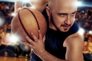 Serious basketball player with ball in the game action photo