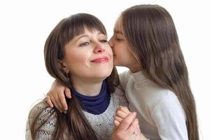 close up of daughter kisses her mother to the cheek photo