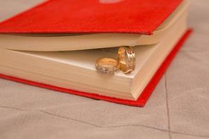 anillos de boda en libro rojo foto