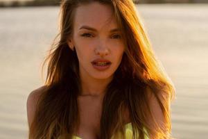 beautiful young girl in the sea at sunset photo