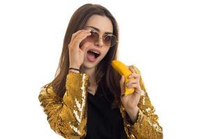 fun stylish woman in golden jacket with banana in hands photo