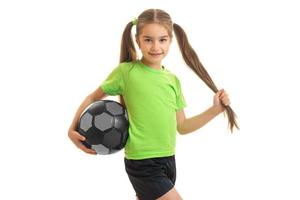 pretty little girl in green shirt with soccer ball in hands photo