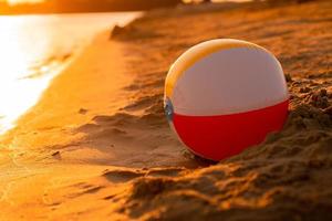 pelota de playa en la orilla del mar al atardecer foto