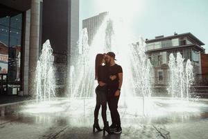 pareja sexy abrazos en la fuente de la ciudad foto