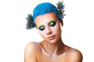 Shy young girl with flowers in hair and multicolor makeup photo