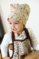 retrato de una linda niñita casera en una cocina blanca. foto