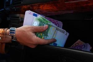 male hands taken out of glove box a lot of money photo