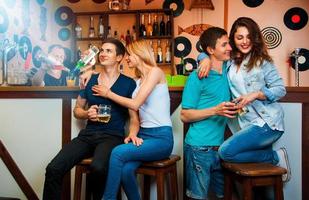 photo of twins with their girlfriend at bar and barman cooking cocktail from behind